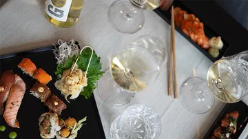 Sushi and wine on a table, elegant presentation.