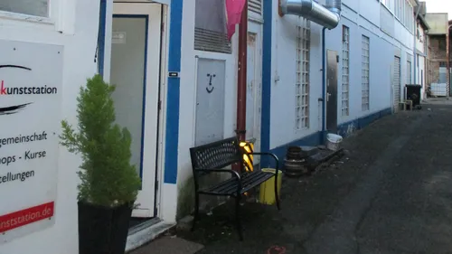 Bänke stehen an einer engen Gasse mit Grafiken.