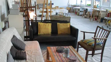 Black sofa with cushions in an ornate, empty setting.