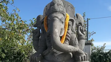 Eine Statue von Ganesha trägt einen blühenden Kranz.