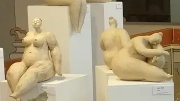 Sculptures sitting, relaxing, in an exhibition space.