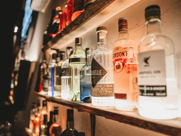 Shelf made of bottles, illuminated, set up in a bar.