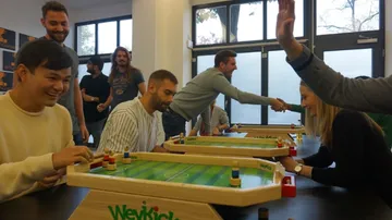 Tischfußballspiel, Spieler interagieren in einem Raum.
