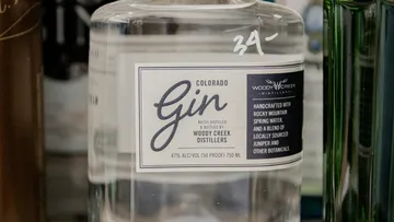 Flasche mit Gin steht auf einem Regal in einer Bar.