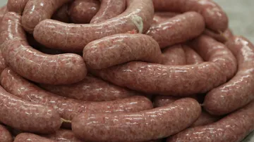 Wurst in großen Mengen übereinander gestapelt, frisch.
