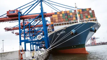Containerschiff liegt an der Pier, Krane heben Fracht.