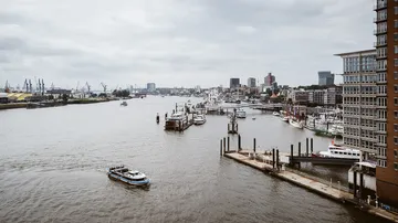 Boats sail on a river in an urban landscape.