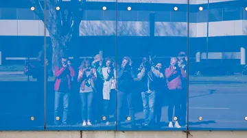 Spiegelnde Wand, Menschen fotografieren auf der Straße.