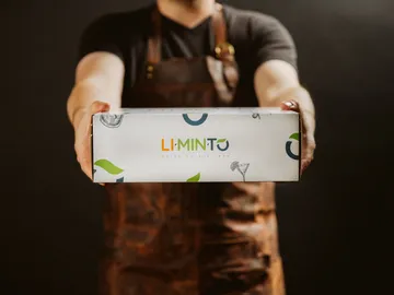 Eine Person reicht eine geschenkte Box, brauner Hintergrund.
