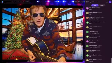 Male musician playing guitar against a Christmas backdrop.
