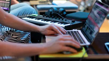 Laptop und Keyboard werden genutzt, um Musik zu erstellen.