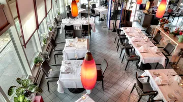 Elegant tables are set in a bright, modern restaurant.
