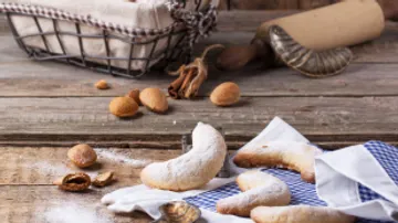 Biscuits are scattered on a wooden table with accessories.