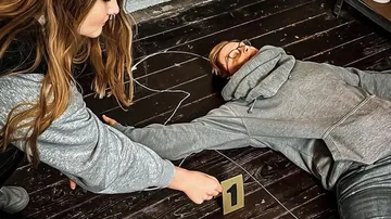 Person zeigt auf eine umgefallene Person mit einer Nummer.