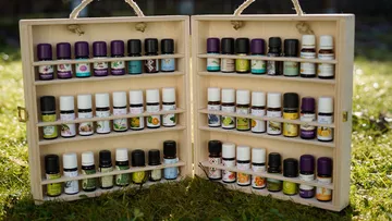 Wooden box with various essential oils, on lawn.