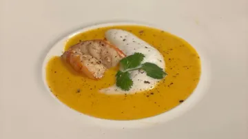Soup with shrimp, cream topping and fresh coriander.