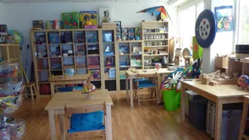A room with tables, shelves, and study materials.