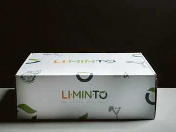 Kartonbox mit Cocktailmotiven auf einem neutralen Hintergrund.