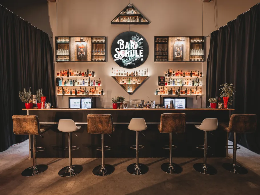 Bar counter with stools and illuminated shelves.