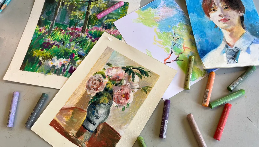 Colourful drawings and pastel chalk on a table.