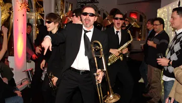 Musiker in Schwarz feiern, spielen Instrumente bei Party.