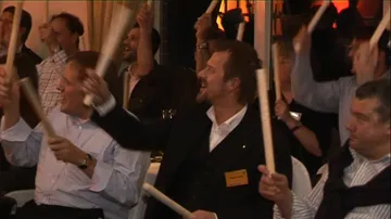 Men swing batons, party in a festive room.