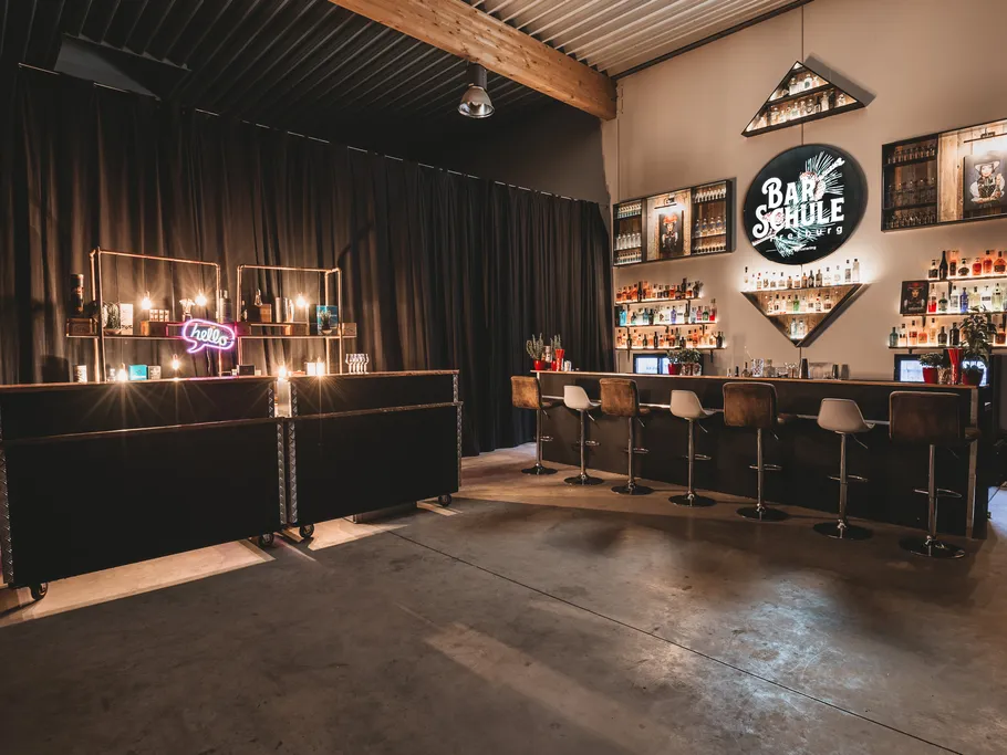 Modern bar setup with stools and shelves.