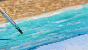 Pinsel malt Wasserfläche auf Leinwand im Freien.