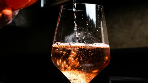 A glass is filled with sparkling drink.
