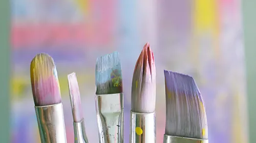 Brushes are lined up, ready to paint, colorful backgrounds.
