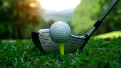 Golfball steht auf Tee, Schläger bereit im grünen Golfplatz.