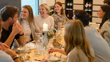 Table with laughing people having a convivial dinner.