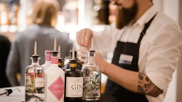 Bartender mixes drinks at the table in a bar.