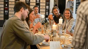 A group is sitting at a table and having a happy conversation.