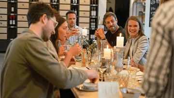 Tisch mit Gästen, die essen und sich unterhalten.