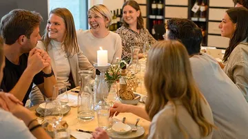 Round table with laughing people over dinner.