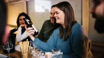 Flasche Bier in der Hand, Freunde genießen gesellige Atmosphäre.