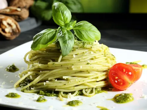 Nudeln Pesto, garniert mit Basilikum und Tomate