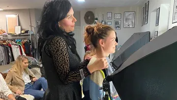 Junge Frau erhält Stylinghilfe in einem kreativen Raum.