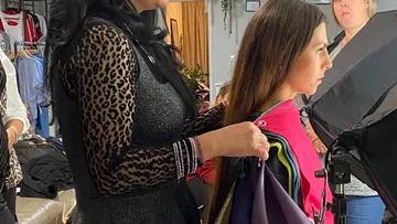 Friseurin stylt das Haar einer jungen Frau im Salon.