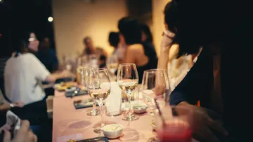 Gläser stehen auf einem Tisch bei einem Abendessen.