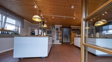Helle Küche mit zentraler Kochinsel und modernen Geräten.