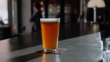 Ein Bierglas steht auf der Theke in einer Bar.