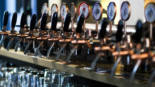 Zapfhähne fügen Bier in Gläser in einer Bar hinzu.