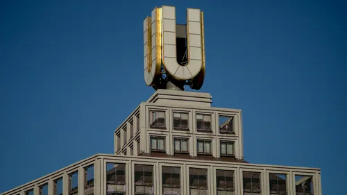 Gebäude mit goldenem "U" zeigt klaren blauen Himmel.