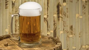 A beer mug is on a wooden table.