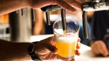 A glass of beer is filled from the tap.