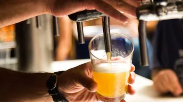 Ein Glas Bier wird an einem Zapfhahn gefüllt.