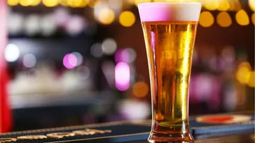 Ein Bierglas steht auf einer Bar, umgeben von Lichtern.