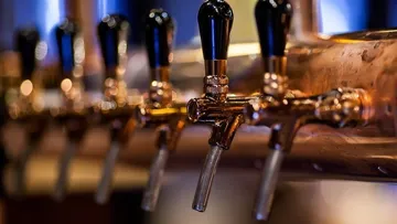 Bierkranen zapfen Getränke in einer Bar-Umgebung.